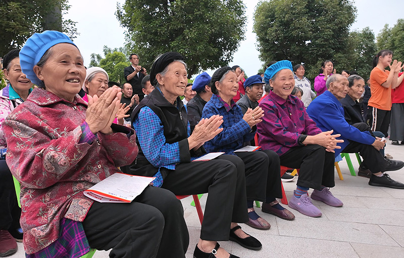 红光“一老一小”关爱服务中心内老人们围坐在一起观看表演-2026年6月15日摄