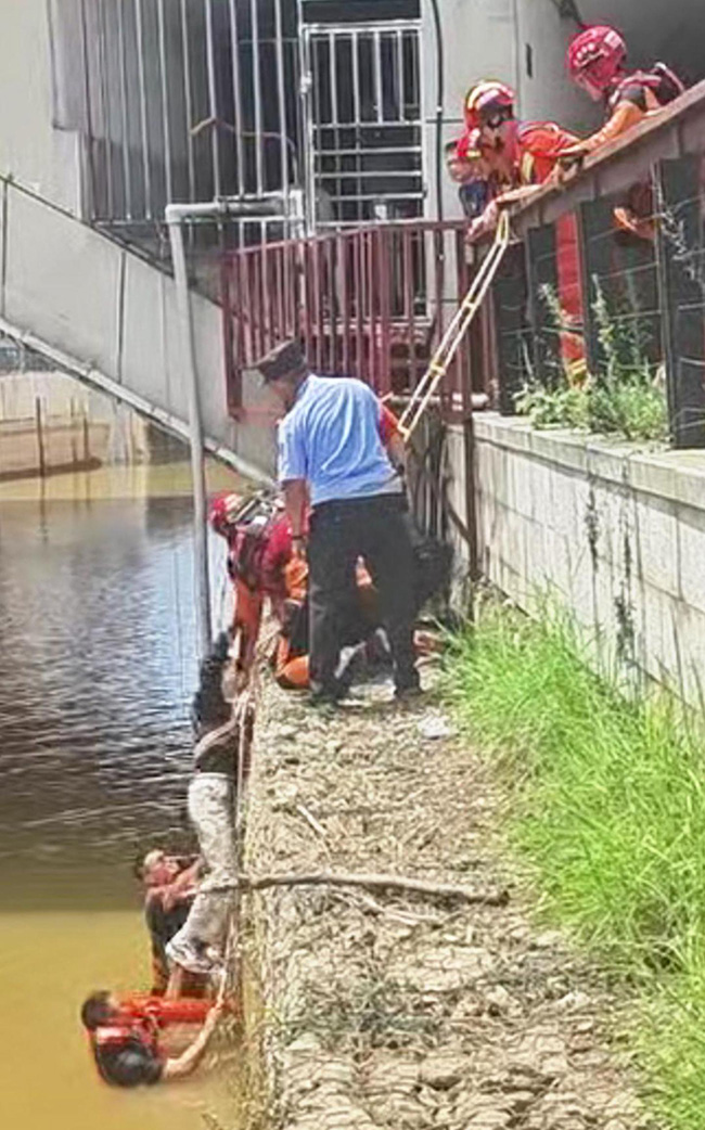 【5】两人奋力托举起男子，众人合力将其拉上岸。曲靖警方供图