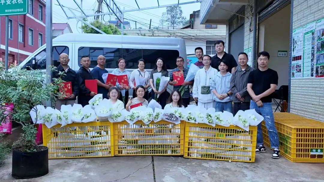 楊萍（后排中）在昆明市湯池街道集貨站為銷量達標的花農頒獎。