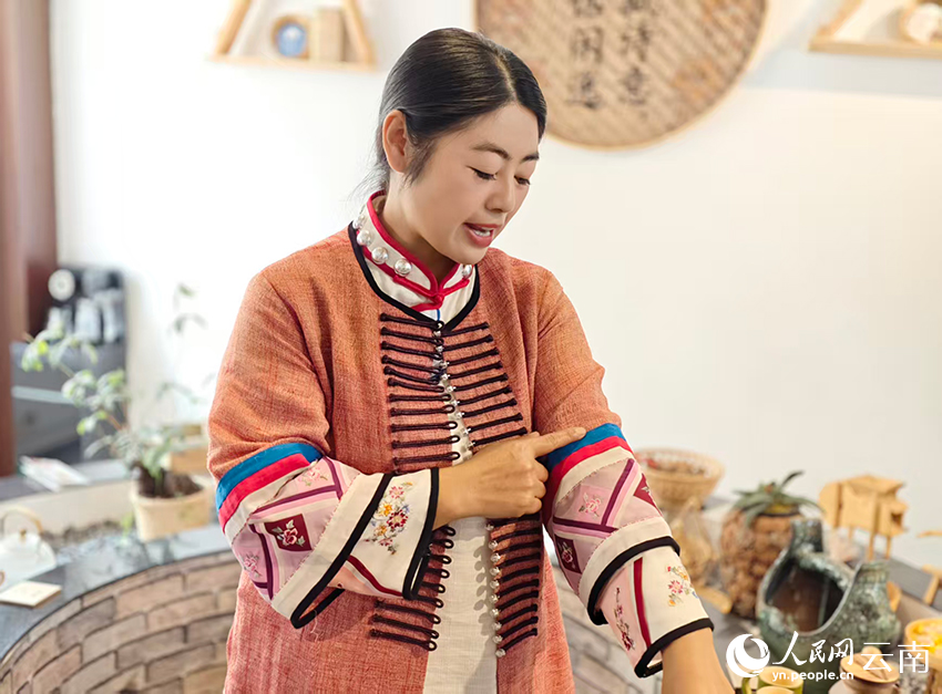 【1】李枝清展示衣服上的布朗族传统纹样。人民网-尹馨摄