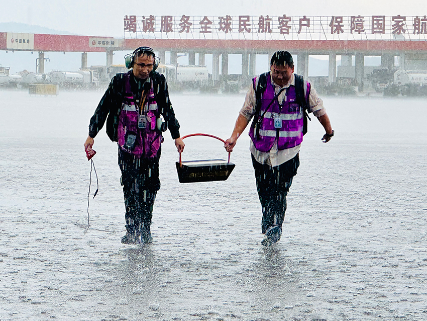 【2】云南空港飞机维修服务有限公司勤务人员在暴雨中执行保障工作。受访者供图