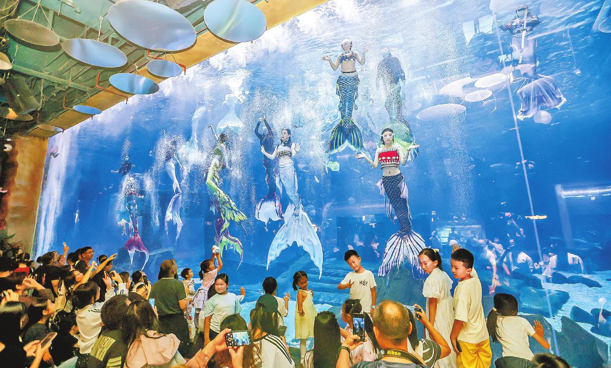 游客在昆明融創海世界海洋館內觀看人魚秀表演。　本報記者　陳飛　攝
