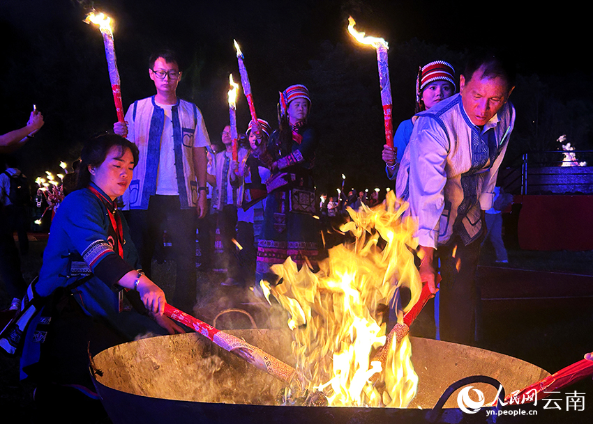 8月5日晚，2026云南石林火把节开幕式上，身着传统服饰的彝族群众点燃火把。人民网记者 刘怡摄