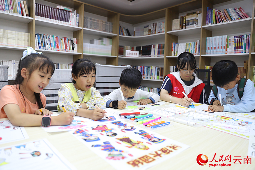 大学生志愿者在辅导孩子们画画。人民网记者 李发兴摄