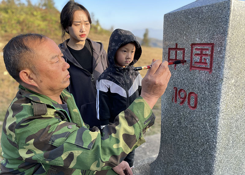 熊光泽带领儿孙为界碑描红。云南省民族事务委员会供图