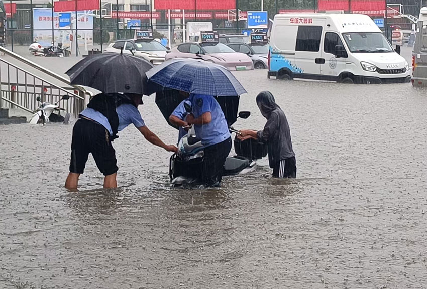 【1】民警輔警蹚入積水，救助受困群眾。思茅警方供圖