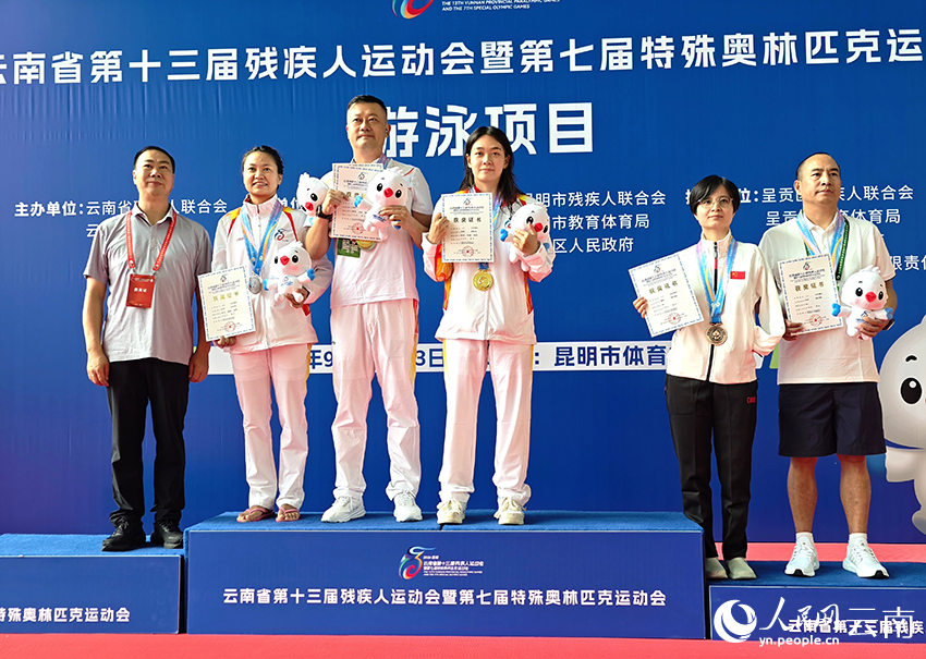 女子100米仰泳S8級決賽前三名的獲獎選手及教練合影。人民網 尹馨攝