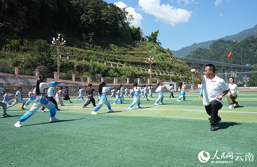 盐津县水田第二小学教师王琪带领学生练习武术动作。刘鑫摄