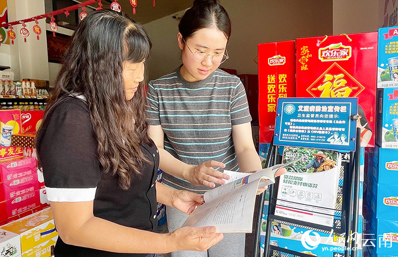 客户经理给杨丽华（左）宣讲相关政策。人民网记者-程浩摄