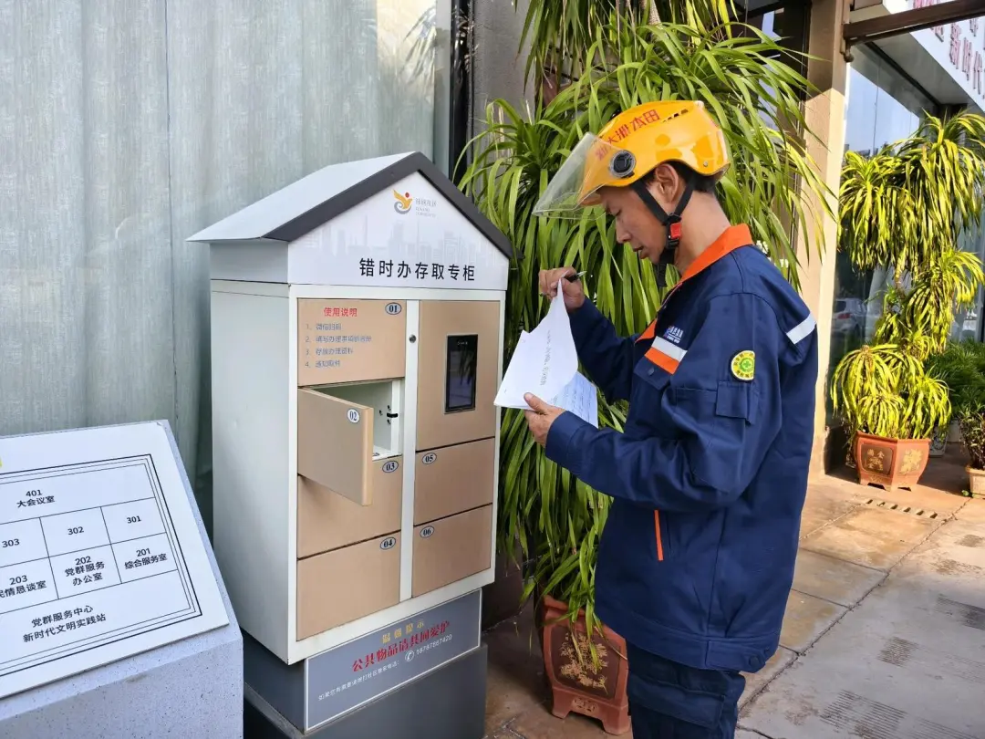 禄钢社区居民在24小时“错时办”服务柜投放办事材料