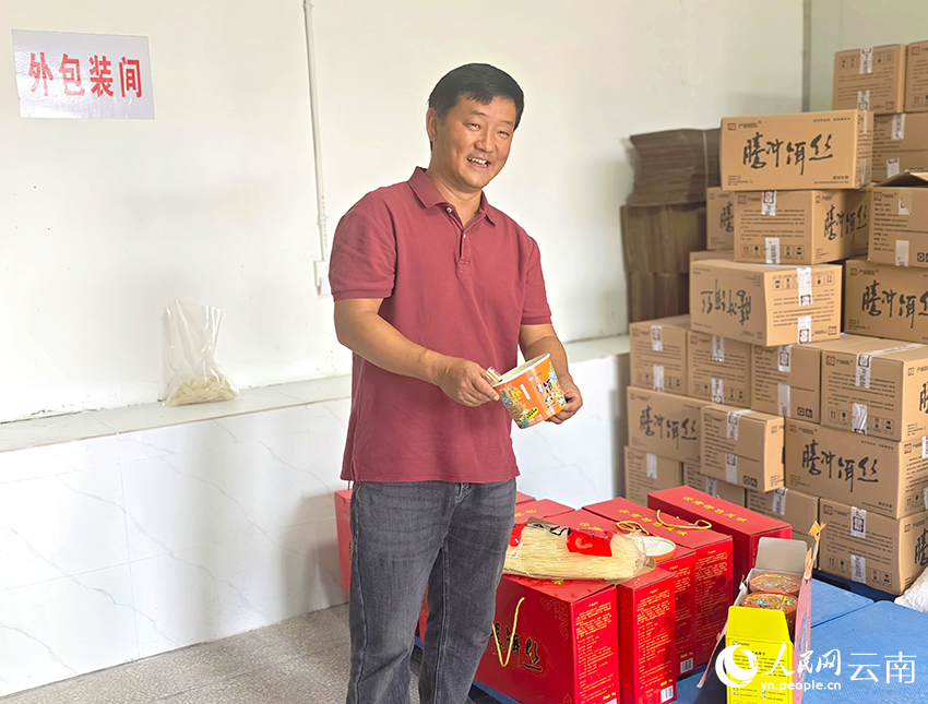 【3】陈小平介绍村里生产的干饵丝产品。人民网-尹馨摄