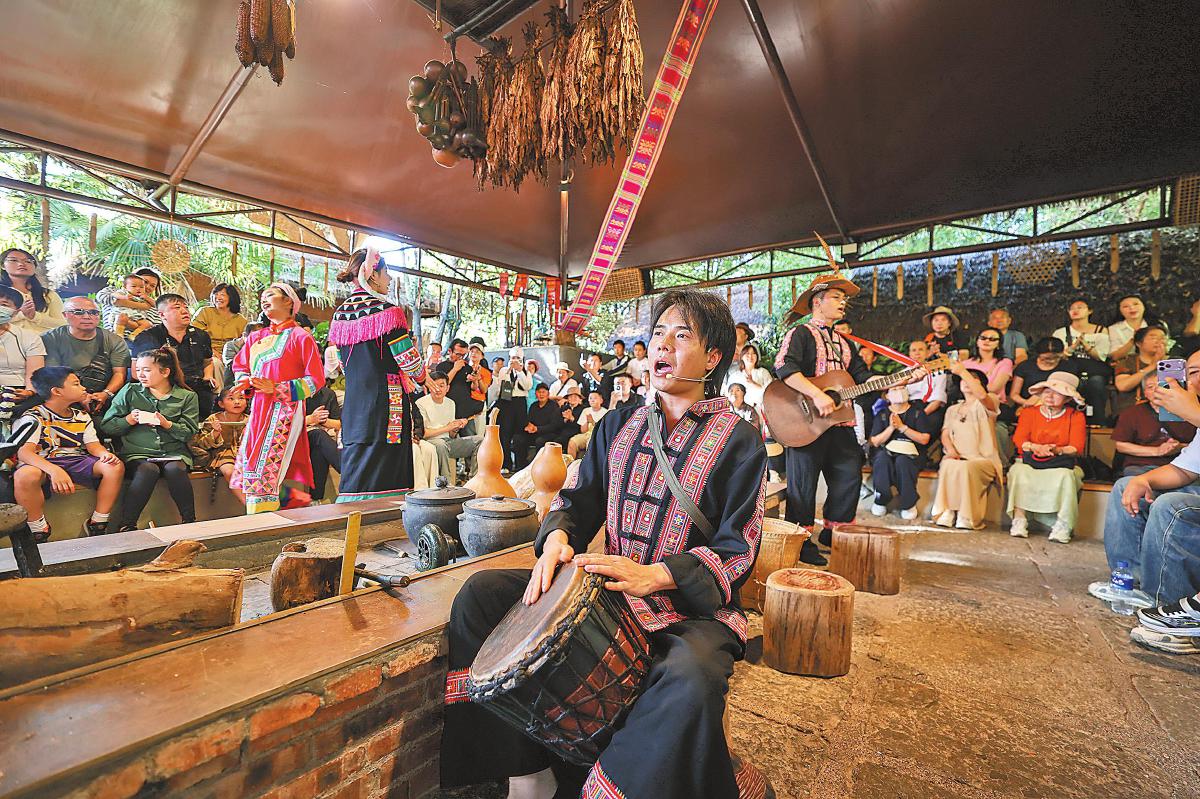 在云南民族村，游客走进村寨品茗共食、围坐欢歌。陈飞摄