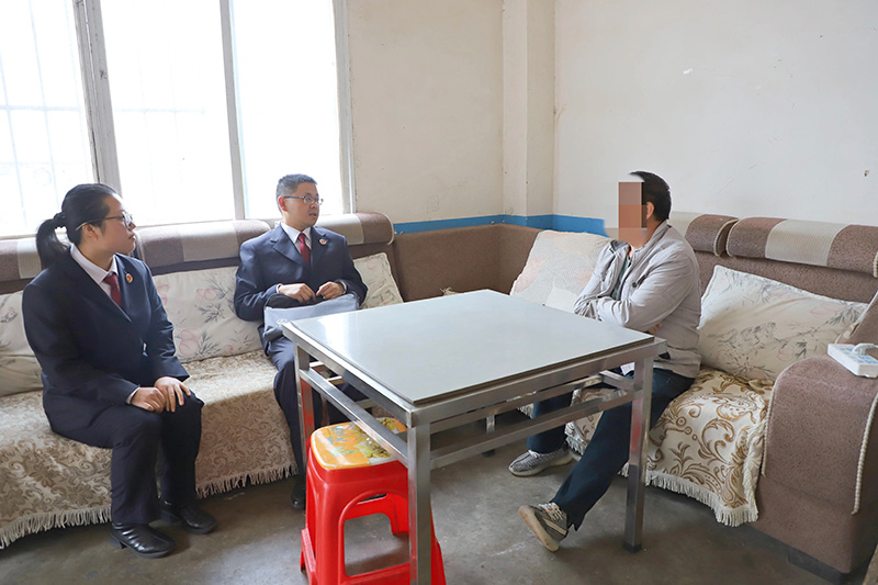 兰荣和同事与当事人袁勇交谈。