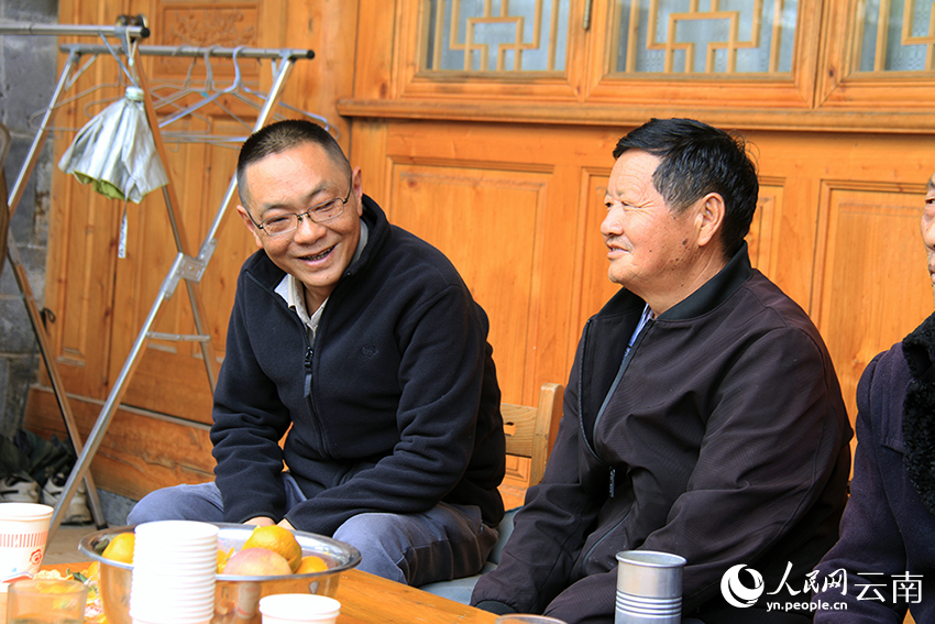 张灿和官接村聊天。人民网记者 程浩摄
