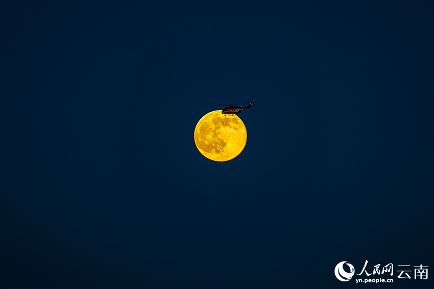 直升机从夜空中飞过。骆银文摄