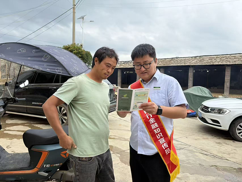 邮储银行金融知识宣传员上门为群众讲解贷款政策。