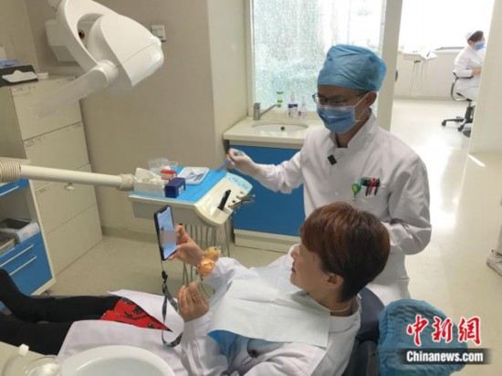 北京协和医院口腔科主治医师董海涛在为患者进行口腔治疗。供图