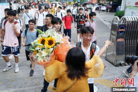 資料圖：6月8日，廣西南寧第二十九中學考點外，考生家長捧著花與考生擁抱。陳冠言 攝