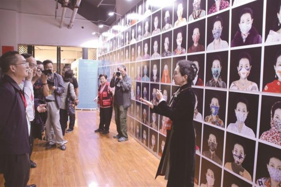 9月1日上午，在垒翠园主展区，摄影师正在向嘉宾和游客介绍作品集《和谐完美 时尚创新——王元晶的时尚摄影作品》。 ［本报记者 吴开睿 摄］