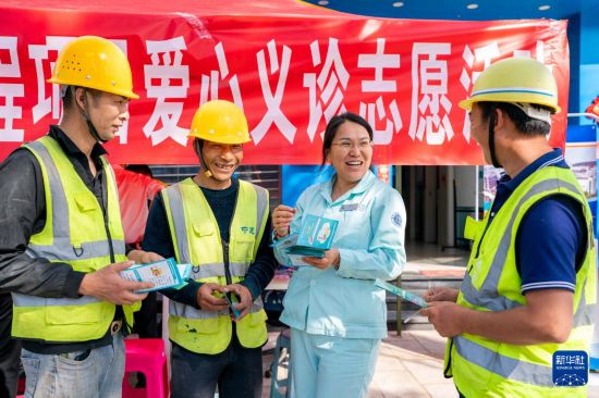 2月28日，昆明理工大学附属安宁市第一人民医院的护士（右二）给工人宣传健康生活知识。新华社记者 胡超 摄