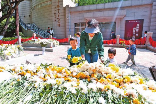 家長帶著孩子來到雲南師范大學瞻仰“一二·一”運動烈士墓並獻上鮮花。 本報記者 陳飛 實習生 門世輝 攝