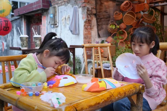 小朋友们在勾勒脸谱。