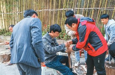 王爱华(右二)在芦笙制作技艺传承培训班上教授学员破笙斗。